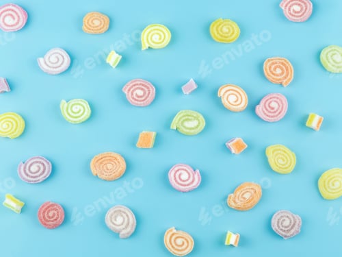 Preview: Top view of colorful sugar jelly candies roll on pastel soft blue background.