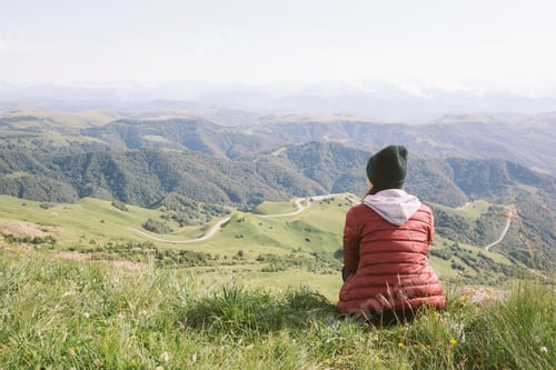 Preview: woman is sitting against background of mountains