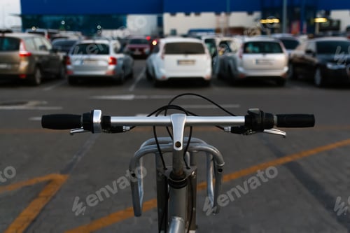 Preview: bike in the parking lot for car, the view from the front. Steering wheel of a silver bicycle with bl