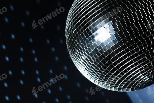 Preview: Shiny disco ball reflecting light in a dimly lit dance venue