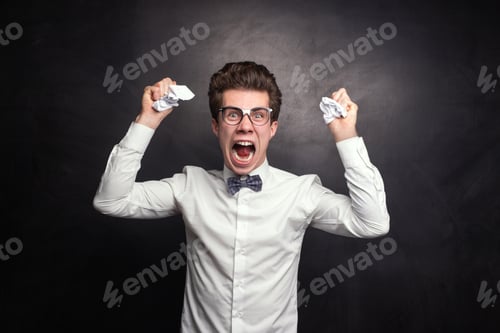 Preview: Angry male student clumping paper