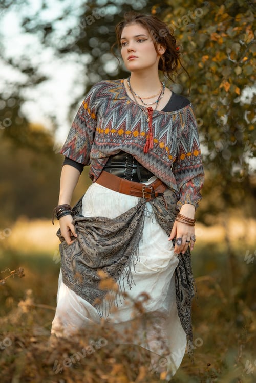 Preview: Young woman in boho style clothes posing in autumn forest