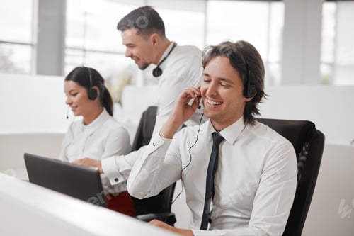 Preview: Positive male call center agent working in office near colleagues