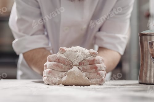 Preview: Baker kneads dough on the table in the bakery