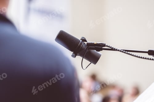 Preview: Man talking on the microphone on stage - public speech