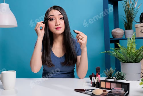 Preview: Portrait of asian beauty vlogger doing her makeup in front of camera