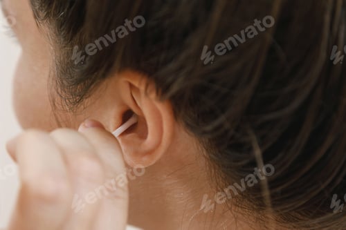 Preview: Woman cleaning ear with a cotton swab