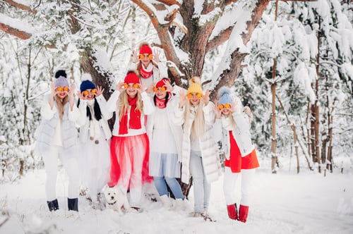 Preview: A large group of girls with tangerines are standing in the winter forest.Girls in red and white