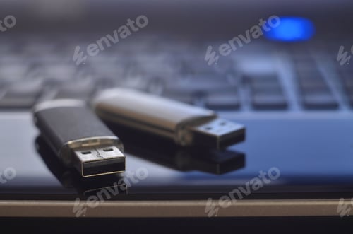 Preview: USB flash cards lying on black laptop case in front of his keyboard