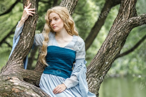 Preview: A young girl in a summer park. A beautiful medieval elf princess in a blue dress in the forest.