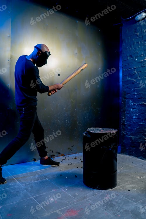 Preview: A man in a protective mask smashes a glass bottle with a bat in a crash room for stress relief