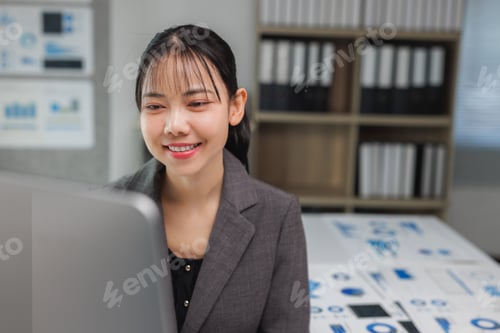 Preview: Businesswoman smiling working on data analysis in office