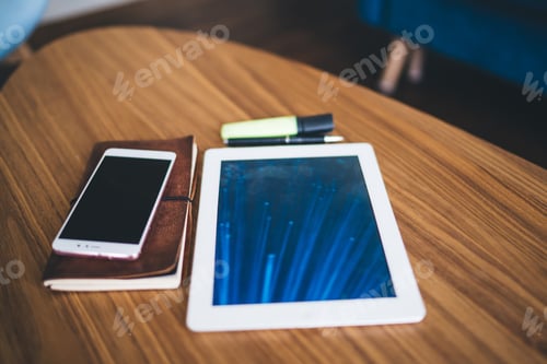 Preview: Tablet placed on table near smartphone placed on notepad