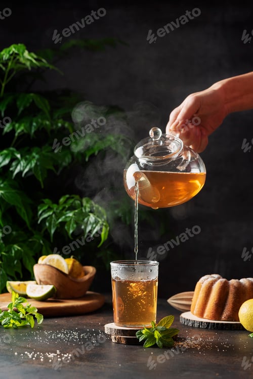 Preview: Woman hand pourung a hot black tea