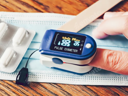 Preview: Closeup shot of a pulse oximeter with pills and a medical protective face mask on the table