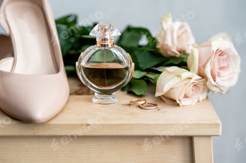Preview: Wedding Shoes, Perfume, and Rings on Wooden Table