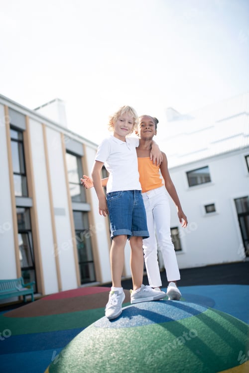 Preview: Boy hugging his beautiful classmate while having fun outside