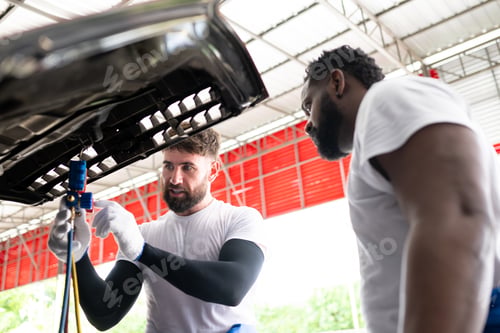 Preview: Car mechanic working in an auto repair shop, inspecting the operation of the car's air conditioner
