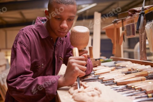 Preview: Apprentice Using Chisel To Carve Wood In Workshop