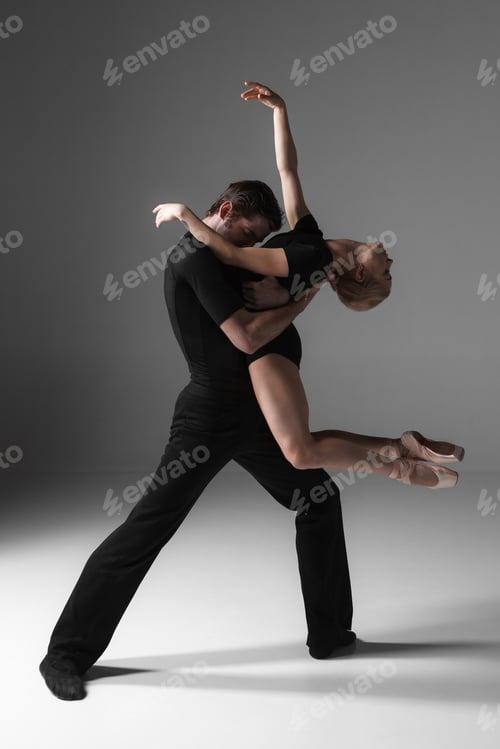 Preview: two young modern ballet dancers on gray studio background