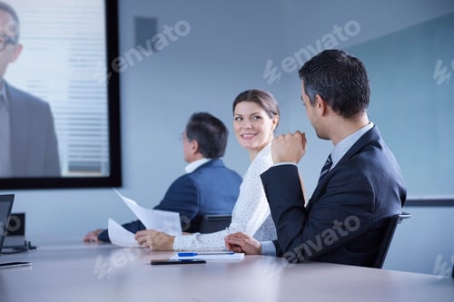 Preview: Businesswoman looking over her shoulder during office conference call