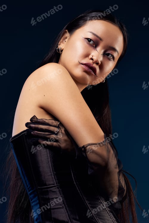 Preview: Creative makeup and dark elegance of a young woman in a corset against a blue background