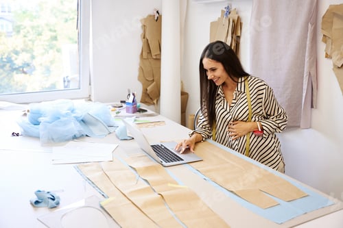 Preview: Pregnant woman is at work in a sewing studio