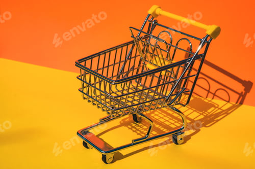 Preview: Empty shopping trolley cart on colorful orange yellow background. Copy space for your text. Online