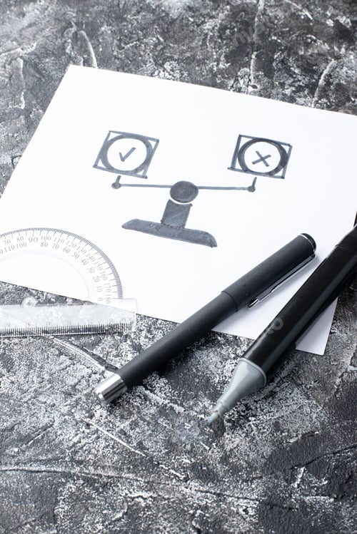 Preview: Close up view of a white sheet with positive and negative icons ruler pens on gray distressed