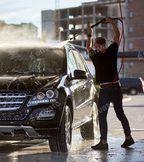 Preview: Sporty man washing his black car outdoors