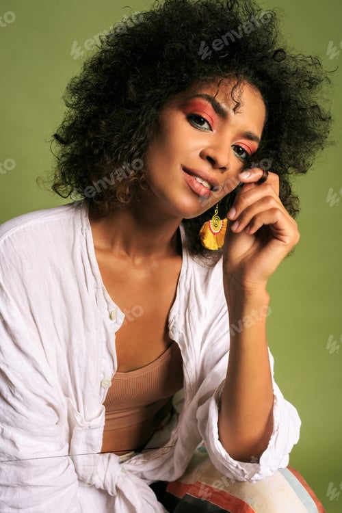 Preview: Fashionable african woman in stylish summer outfit posing over green background in studio.