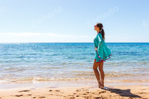 Vista previa: woman in white clothing refreshing at the beach on a sunny day