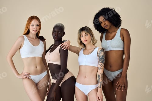 Preview: Multiethnic girls beauty models posing on beige background. Group portrait.
