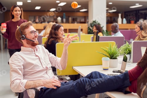 Preview: Businessman Wearing Headset Playing With Stress Ball Talking To Caller In Customer Services Centre