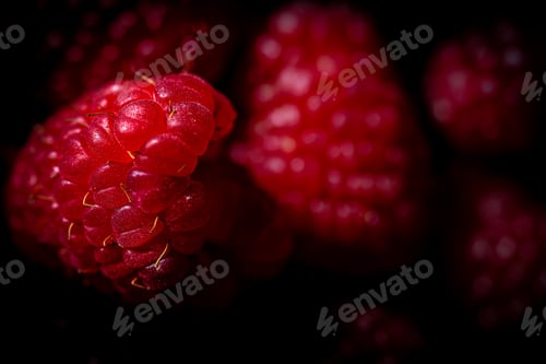 Vista previa: Close-up of freshly-picked raspberries on a dark surface
