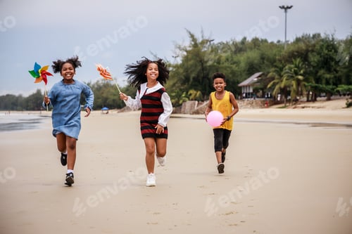 Preview: Happy Group of African American kids enjoying to play with toy on the beach