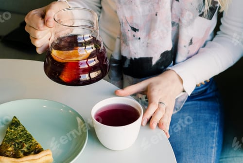 Visualização: Garota servindo chá. Xícara de chá