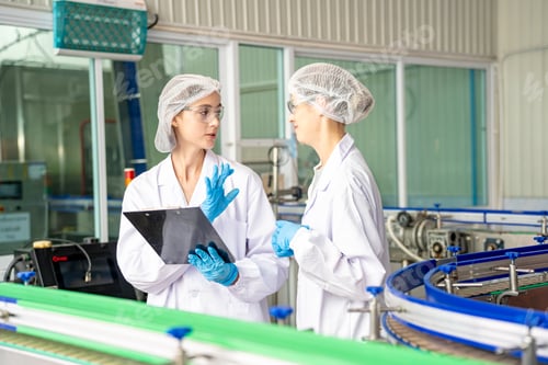 Preview: Female worker inspecting water bottle on production line in spring water factory