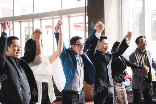 Preview: large business team showing unity with their hands together, business team celebrating