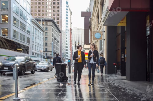 Preview: Two businesswomen walking in city and talking