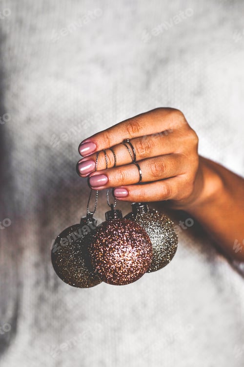 Preview: Woman in warm sweater holding toys glass decorative balls in hands, copy space. Christmas, new year