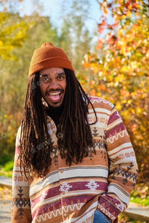 Preview: African young man with dreadlocks laughing and looking at camera in fall.