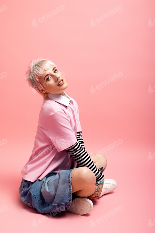 Preview: Young woman radiates joy in playful pose against a vibrant pink background