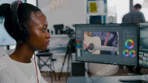 Preview: African woman videographer with headphones editing video footage