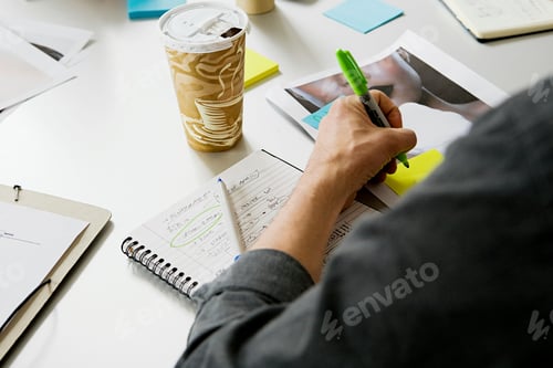 Preview: Young man writing on adhesive note