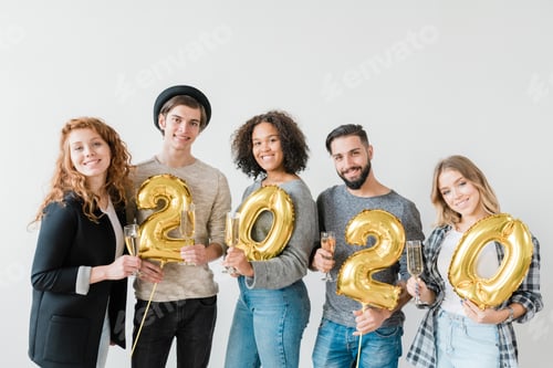 Preview: Young joyful friendly people holding number of new year and flutes with chamagne