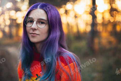 Preview: Girl teenager with bright purple hair wearing glasses and colorful sweater.