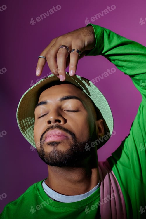 Preview: close up young african american man in green panama posing with closed eyes, fashion concept