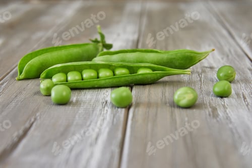 Preview: Opened pods of fresh green peas on wooden background