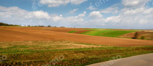 Preview: spring areas of arable fields and winter wheat, lines and hills.